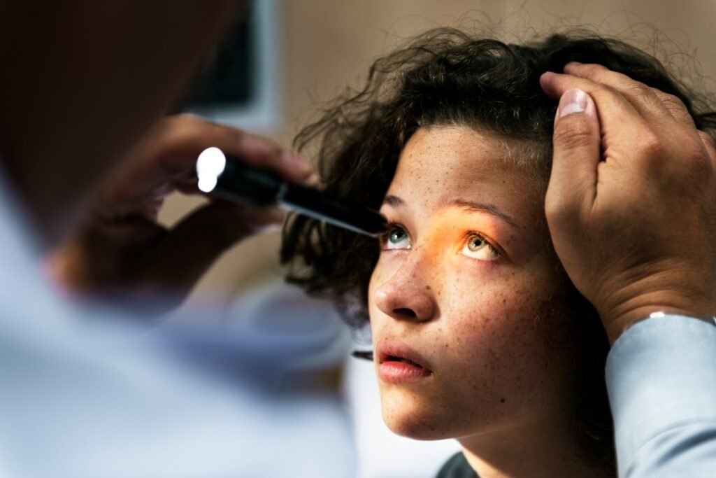 A child has their eyes looked at by an optician
