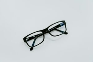 A pair of black prescription glasses on minimal white background