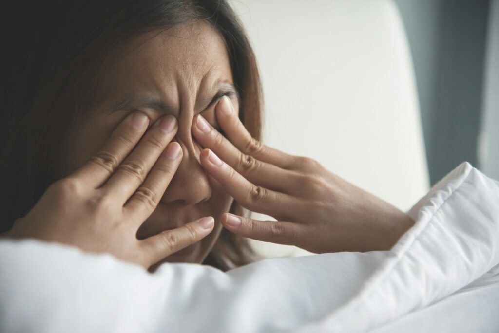 close up of woman holding her eyes with her hands because they're so itchy